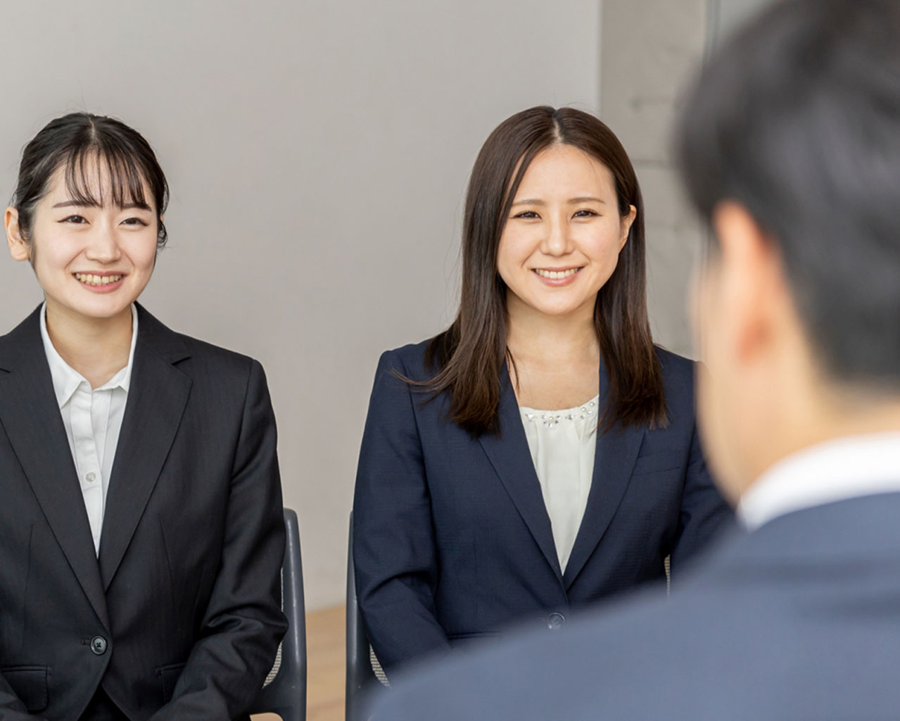 グループ面接で自信を持って話すリクルートスーツ姿の女子大学生